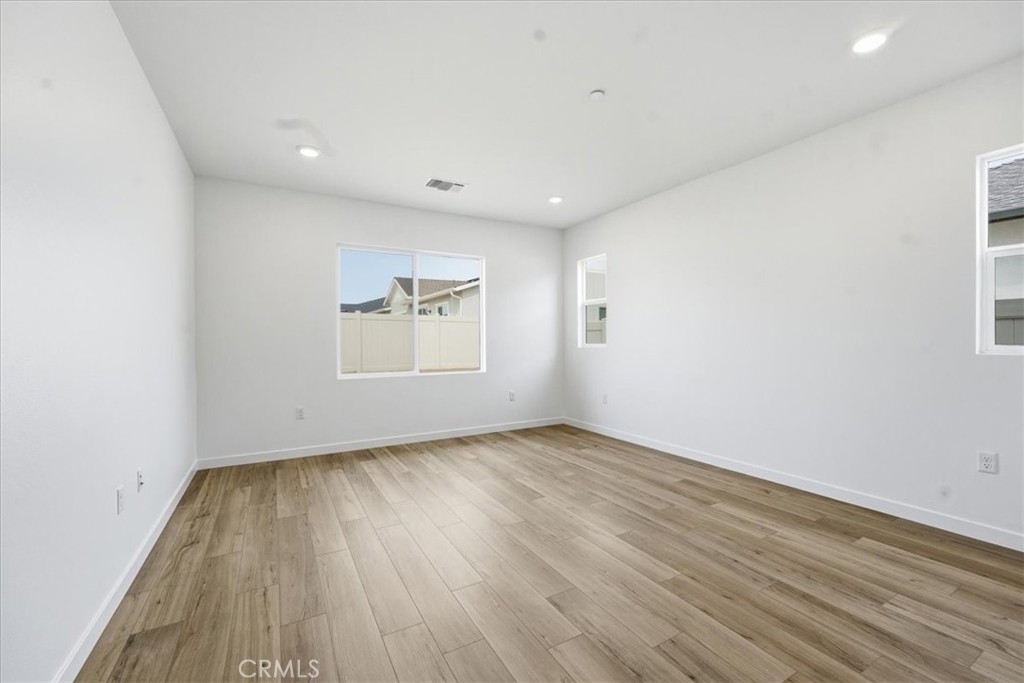 42957 56th Street West Lancaster, CA 93536 - Photo 22 of 40 an empty room with wooden floor and windows