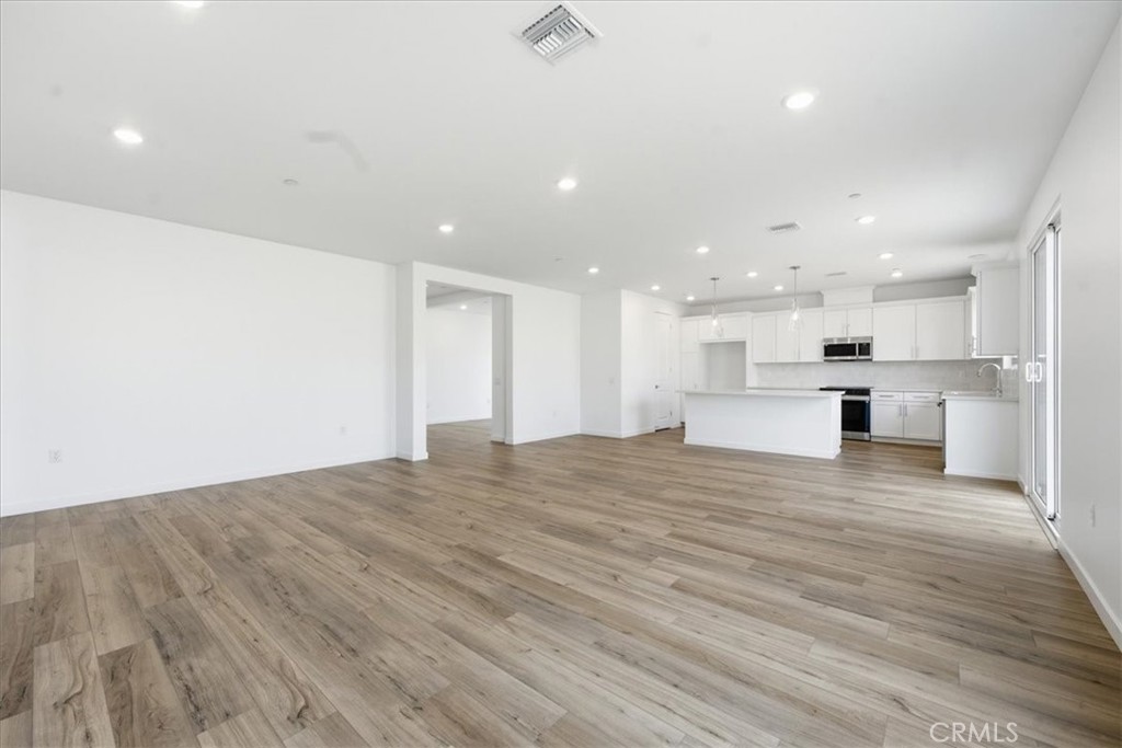 42957 56th Street West Lancaster, CA 93536 - Photo 6 of 40 a view of kitchen with kitchen island a sink wooden floor and a refrigerator
