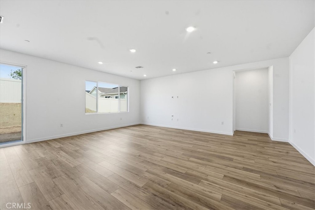 42957 56th Street West Lancaster, CA 93536 - Photo 7 of 40 a view of an empty room with wooden floor and a window