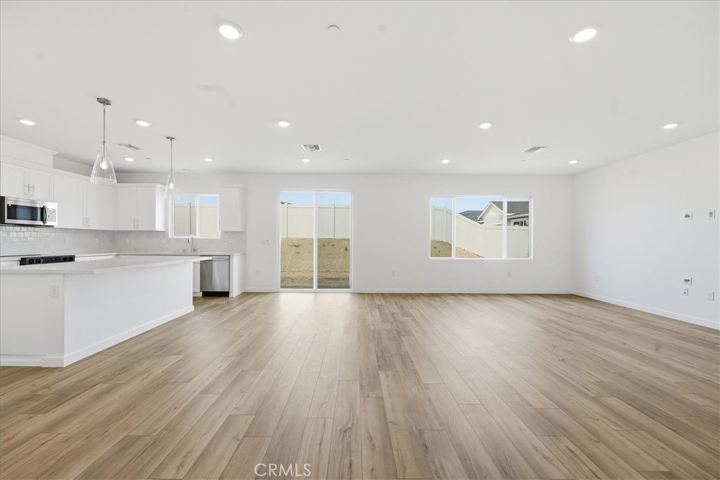 42957 56th Street West Lancaster, CA 93536 - Photo 9 of 40 a view of an empty room with wooden floor and a window