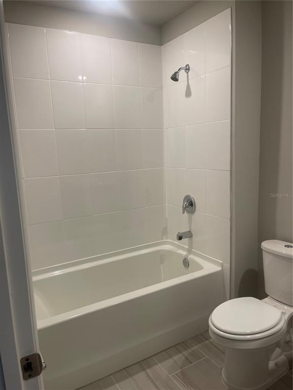 452 Legacy Loop Davenport, FL 33896 - Photo 19 of 29 a white toilet sitting next to a bath tub