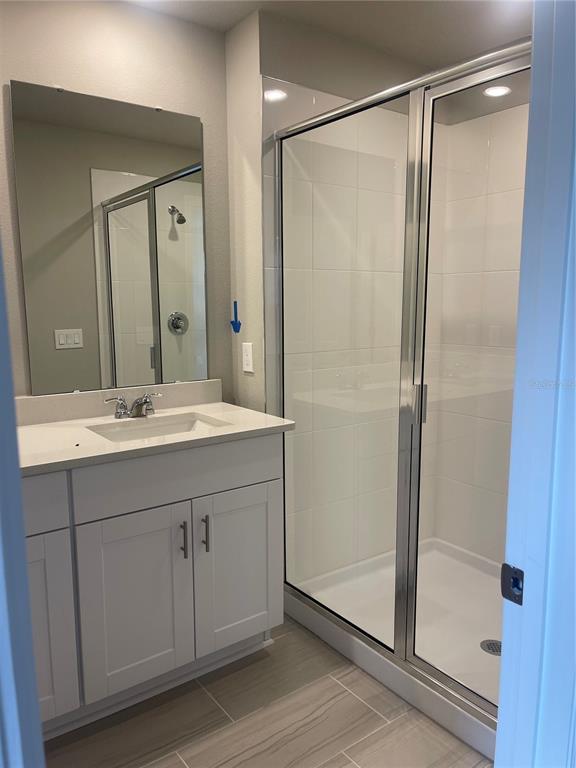 452 Legacy Loop Davenport, FL 33896 - Photo 26 of 29 a bathroom with a shower sink vanity and mirror