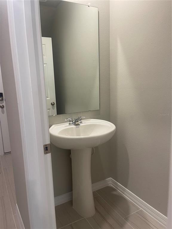 452 Legacy Loop Davenport, FL 33896 - Photo 5 of 29 a bathroom with a sink and mirror