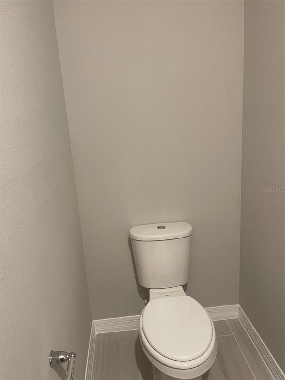 452 Legacy Loop Davenport, FL 33896 - Photo 6 of 29 a white toilet sitting next to a white cabinet