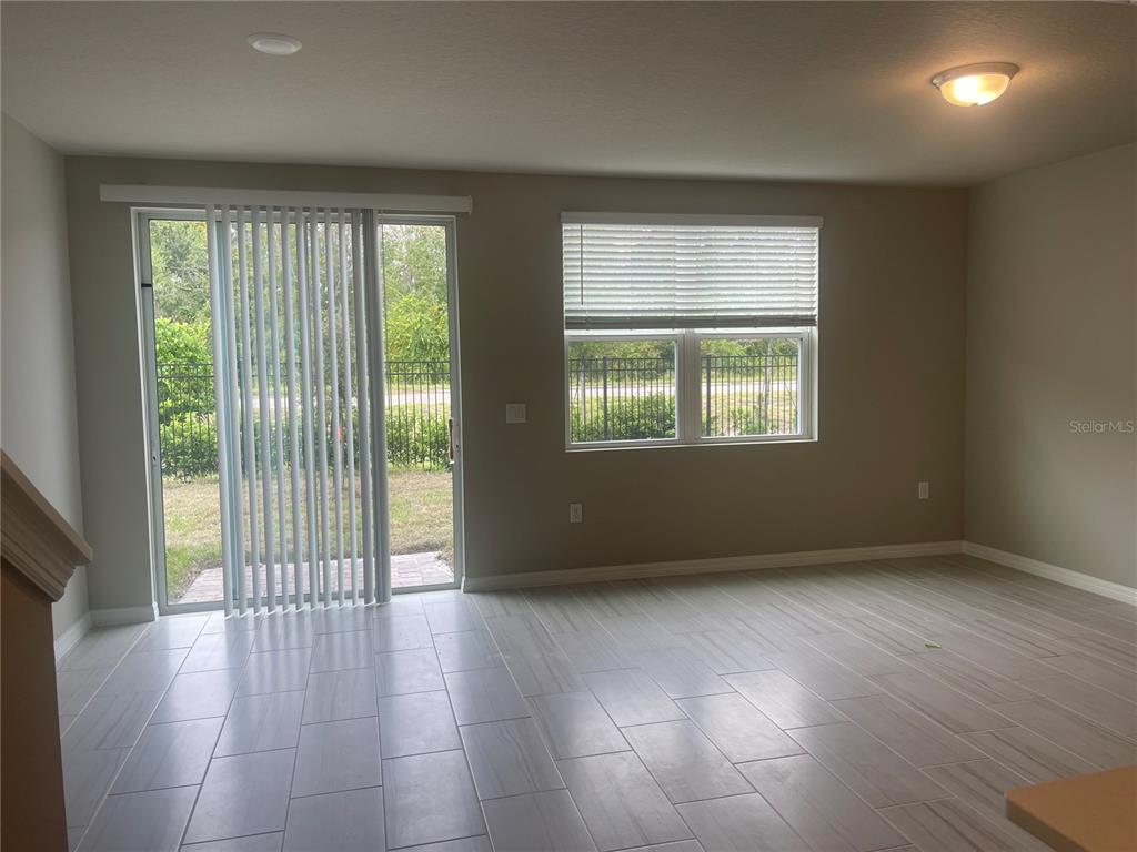 452 Legacy Loop Davenport, FL 33896 - Photo 9 of 29 an empty room with wooden floor and windows