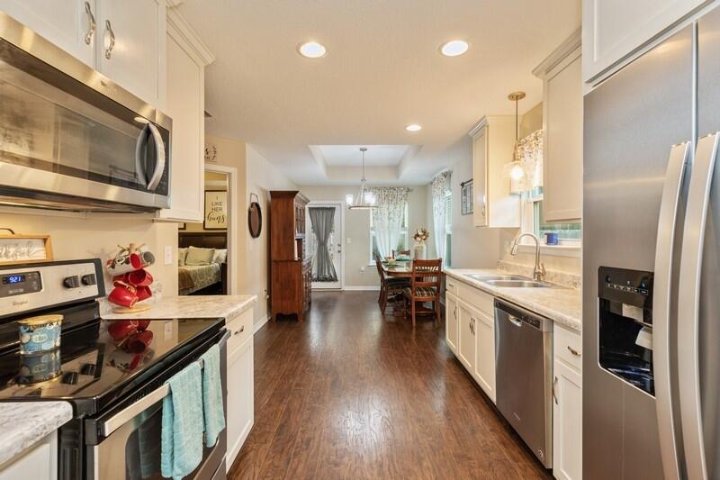 3152 Vaccari Court Crestview, FL 32539 - Photo 15 of 36 a kitchen with stainless steel appliances granite countertop a refrigerator a stove top oven a sink dishwasher and wooden cabinets with wooden floor