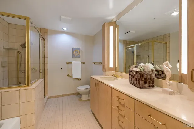 a bathroom with a sink a toilet and shower