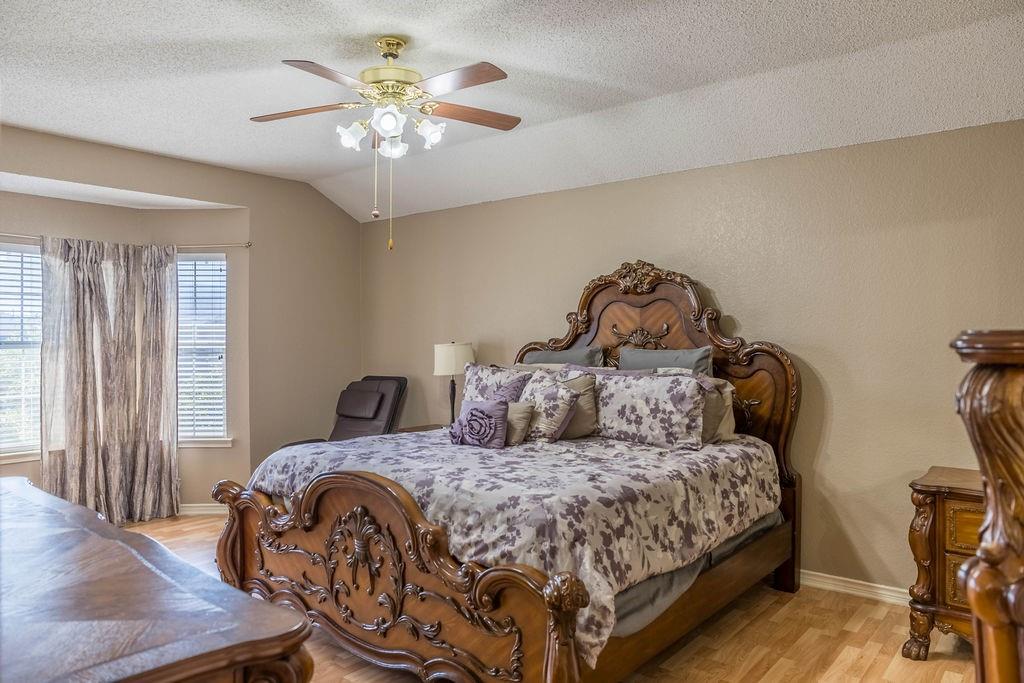 4113 Bluffpoint Road Rowlett, TX 75088 - Photo 17 of 39 Bedroom with light wood-style floors, a textured ceiling, vaulted ceiling, and a ceiling fan