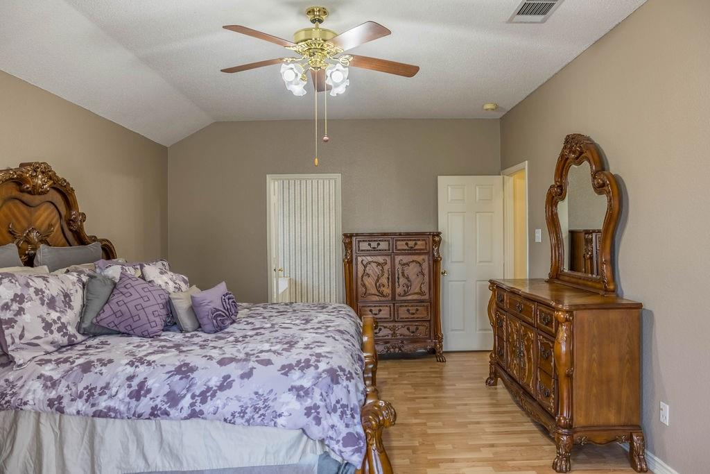 4113 Bluffpoint Road Rowlett, TX 75088 - Photo 19 of 39 Bedroom featuring lofted ceiling, light wood-style floors, and a ceiling fan