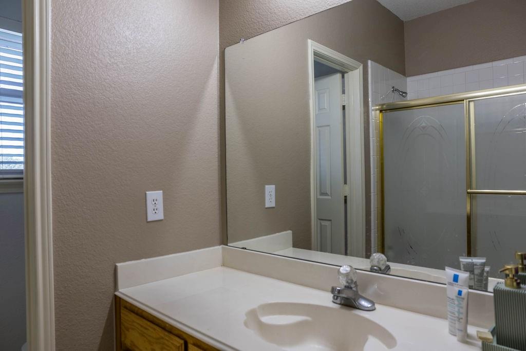 4113 Bluffpoint Road Rowlett, TX 75088 - Photo 23 of 39 Full bathroom with a textured wall, vanity, and a shower stall