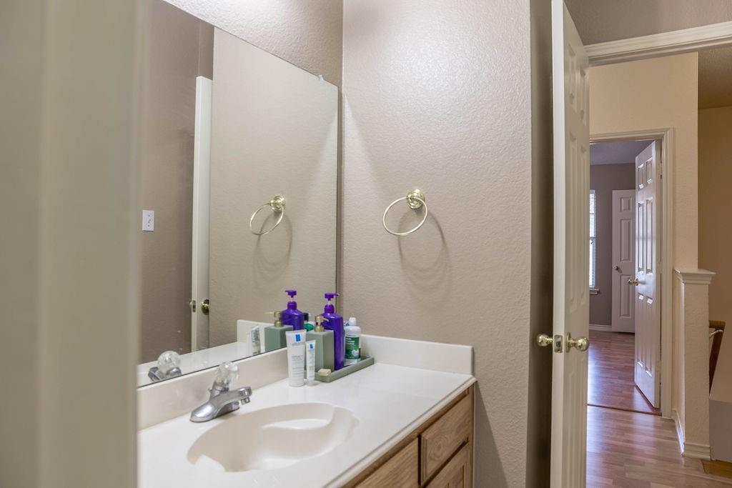 4113 Bluffpoint Road Rowlett, TX 75088 - Photo 24 of 39 Half bathroom with a textured wall, vanity, and light wood-style floors