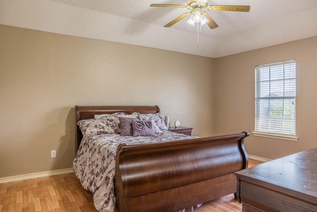 4113 Bluffpoint Road Rowlett, TX 75088 - Photo 31 of 39 Bedroom featuring light wood-style flooring, ceiling fan, and a textured ceiling