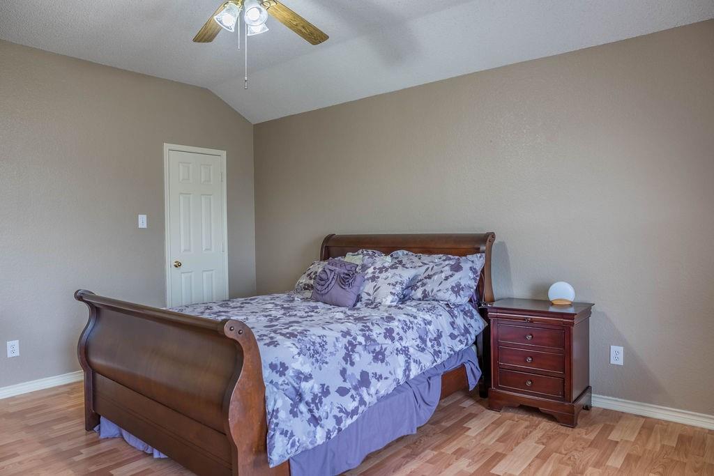4113 Bluffpoint Road Rowlett, TX 75088 - Photo 33 of 39 Bedroom featuring light wood finished floors, vaulted ceiling, and ceiling fan