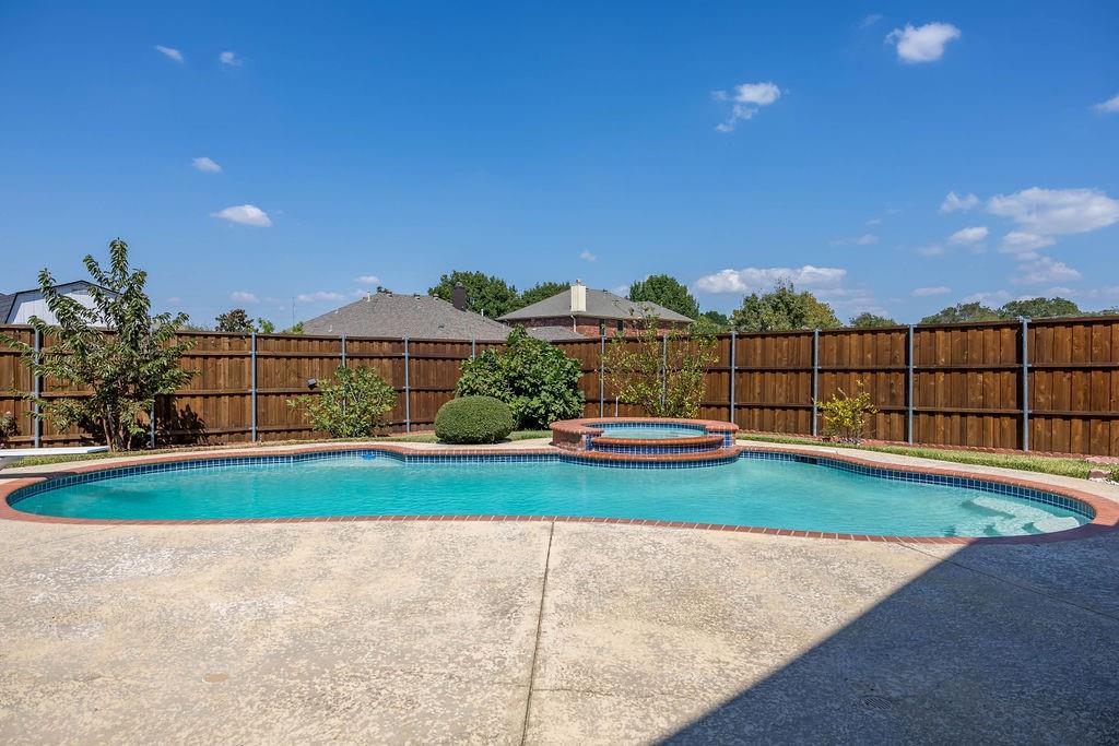 4113 Bluffpoint Road Rowlett, TX 75088 - Photo 35 of 39 View of swimming pool with a fenced backyard, a pool with connected hot tub, and a patio