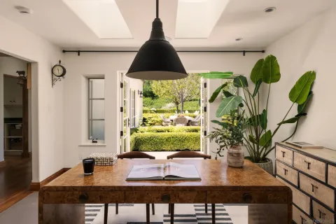a table with a computer on it and next to a window