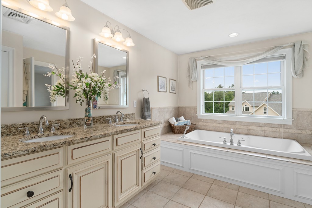 36 Draper Woods Road Sturbridge, MA 01518 - Photo 18 of 25 a bathroom with a granite countertop sink mirror and a bathtub