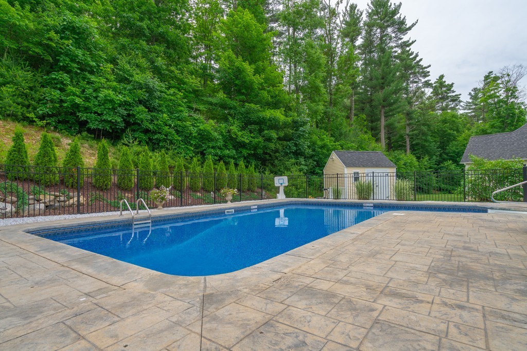 36 Draper Woods Road Sturbridge, MA 01518 - Photo 21 of 25 a view of a swimming pool with a patio