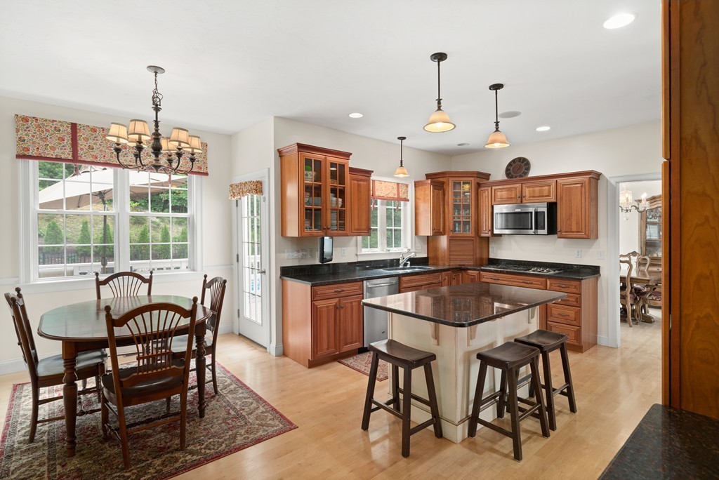 36 Draper Woods Road Sturbridge, MA 01518 - Photo 4 of 25 a kitchen with a dining table chairs and large windows