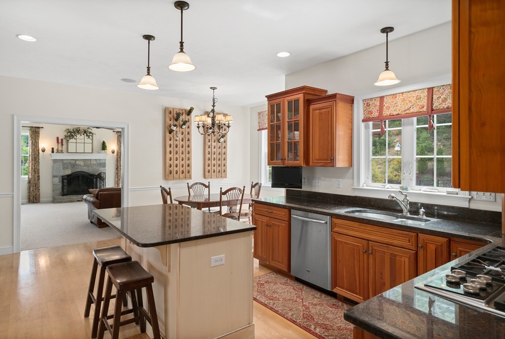 36 Draper Woods Road Sturbridge, MA 01518 - Photo 5 of 25 a kitchen with stainless steel appliances granite countertop a stove a sink dishwasher a couches and chairs with wooden floor