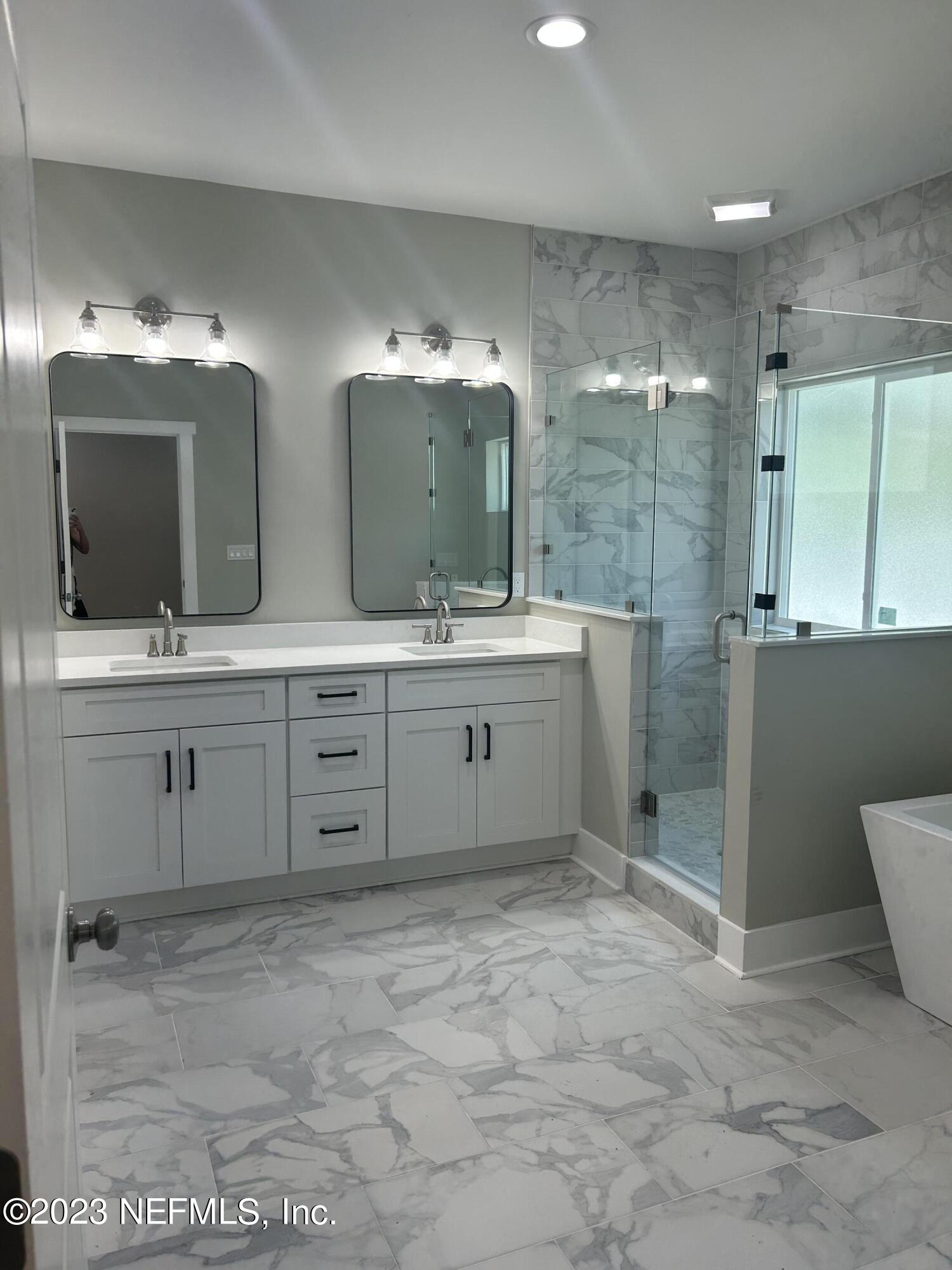 502 Twenty-First Street St. Augustine, FL 32084 - Photo 13 of 14 a bathroom with a double vanity sink mirror and shower