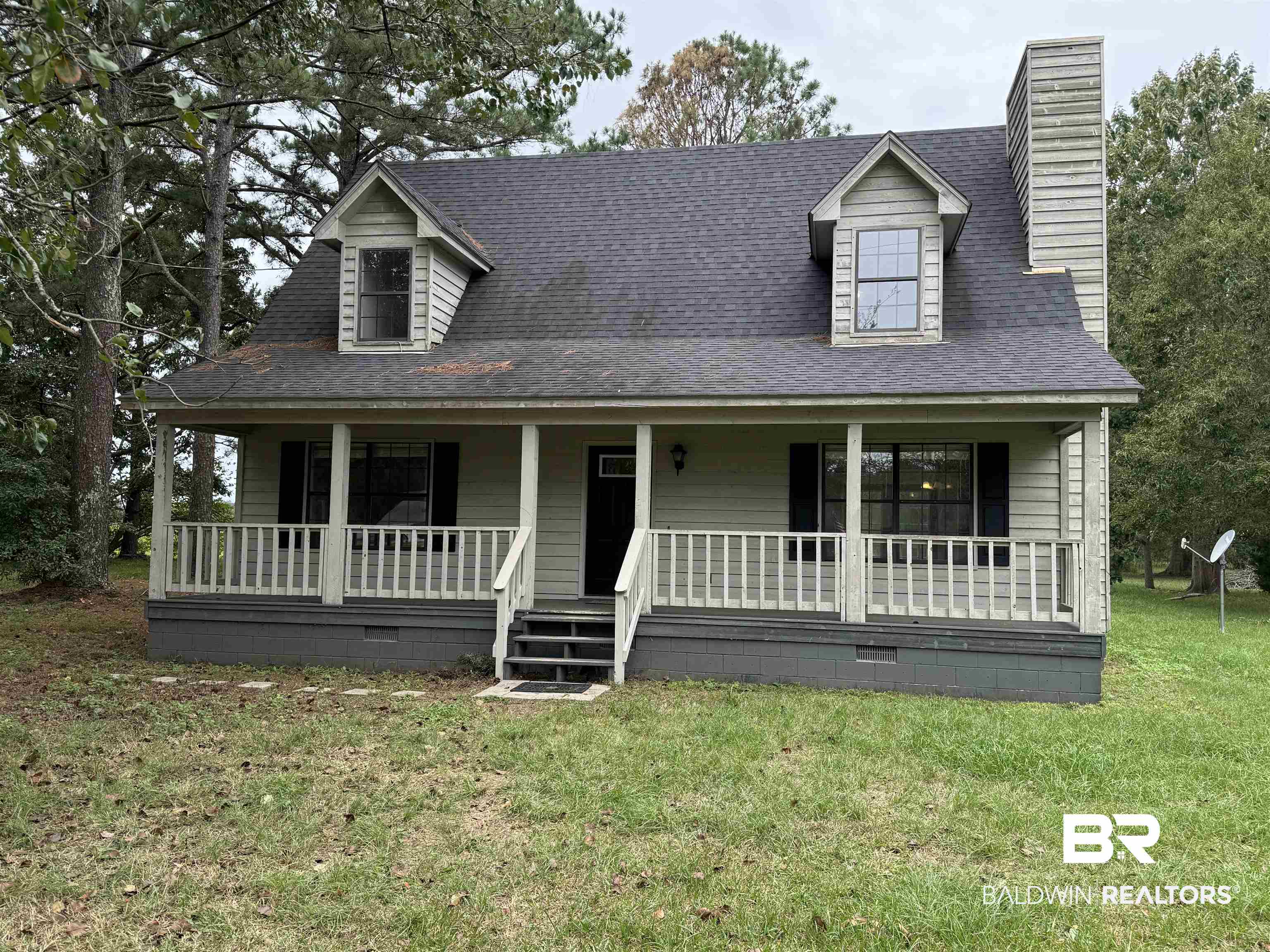 Cape cod-style house featuring a porch and a front lawn