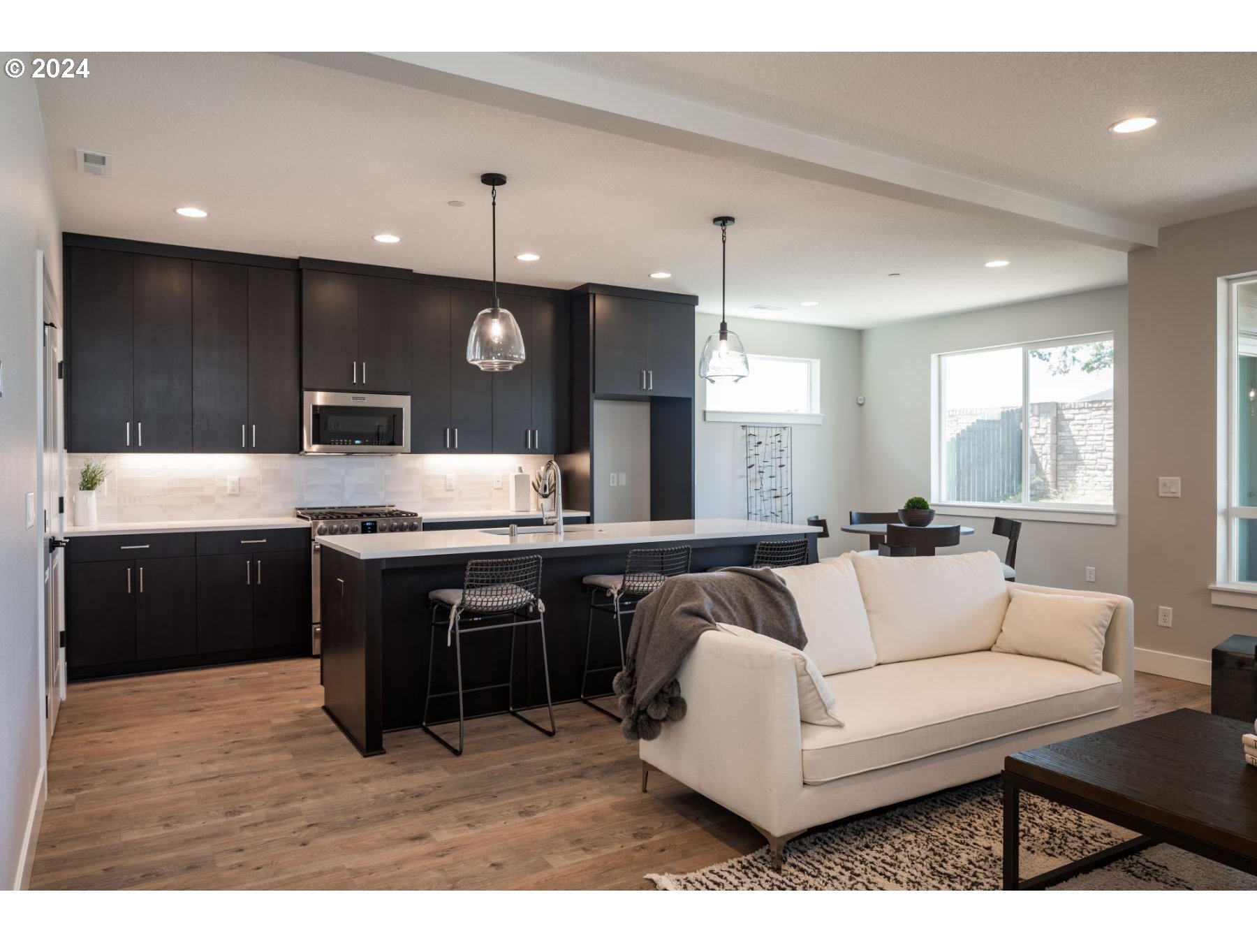 1017 South 46th Place Ridgefield, WA 98642 - Photo 4 of 23 a living room with stainless steel appliances kitchen island granite countertop a rug a stove a counter space and a refrigerator