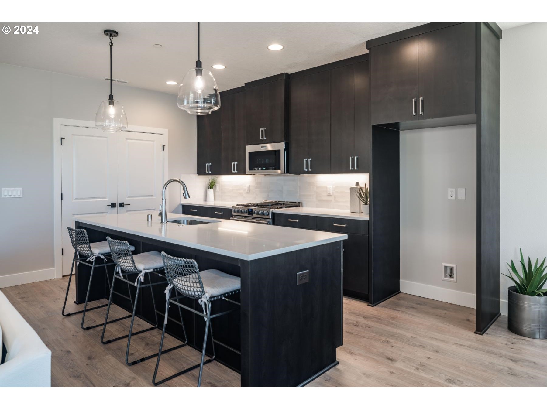 1017 South 46th Place Ridgefield, WA 98642 - Photo 6 of 23 a kitchen with kitchen island stainless steel appliances a sink cabinets and wooden floor