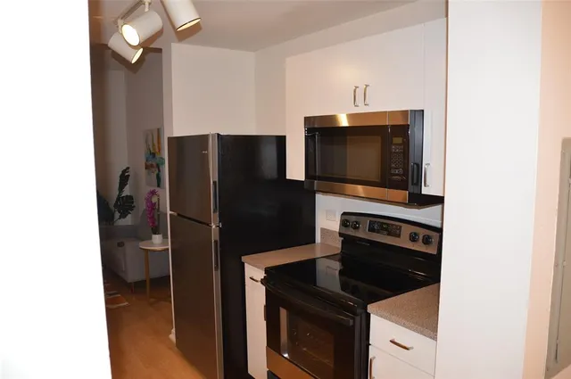 a kitchen with a refrigerator and a stove top oven
