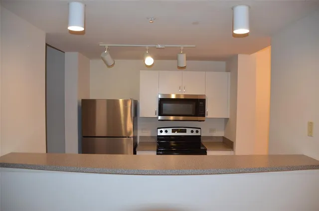 a kitchen with a refrigerator and a stove top oven