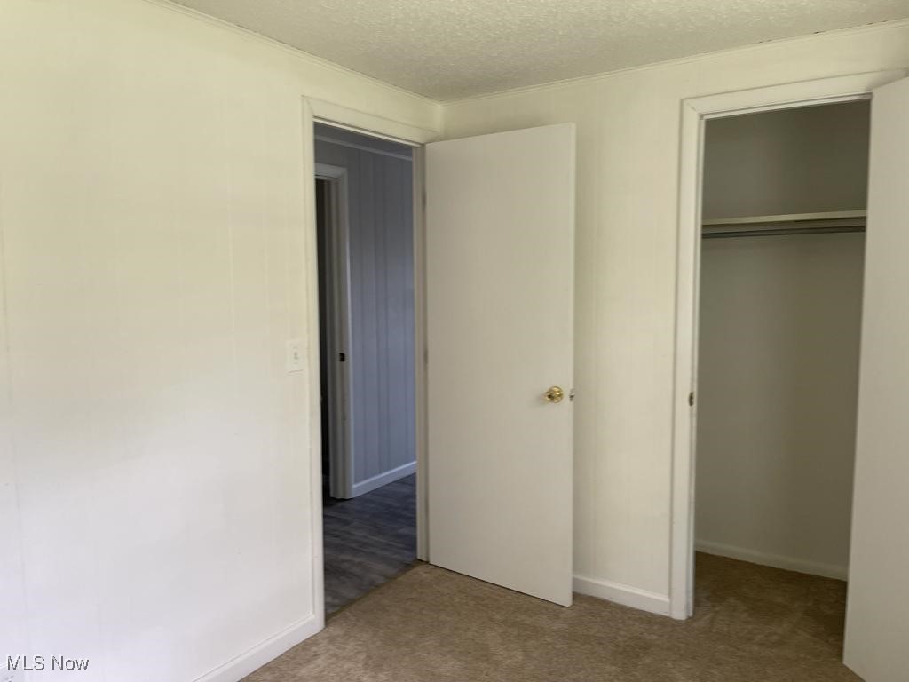 715 South Abbe Road Elyria, OH 44035 - Photo 8 of 14 Unfurnished bedroom featuring a closet, a textured ceiling, and carpet floors