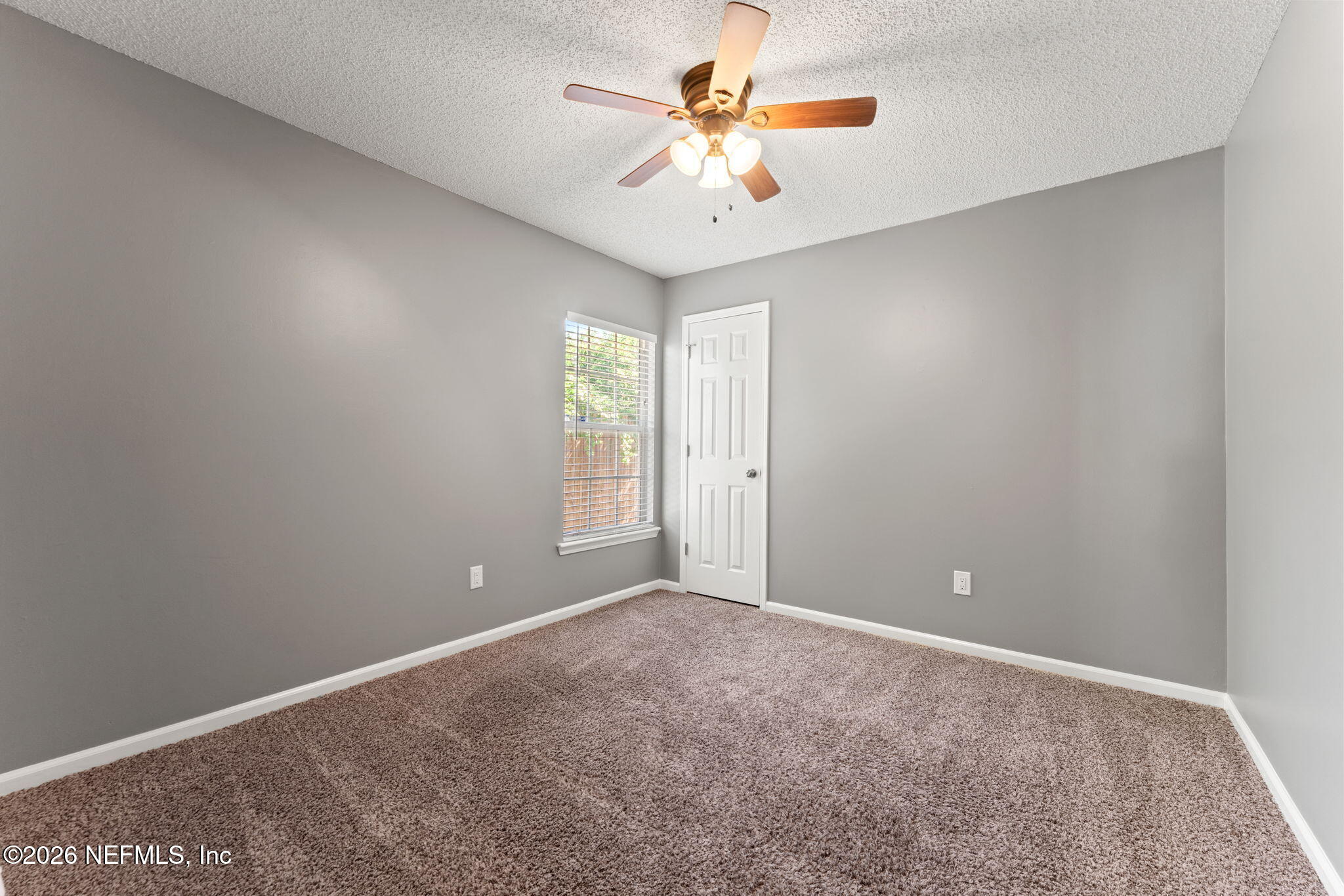 2982 Chief Ridaught Trail Middleburg, FL 32068 - Photo 23 of 29 an empty room with windows and chandelier fan