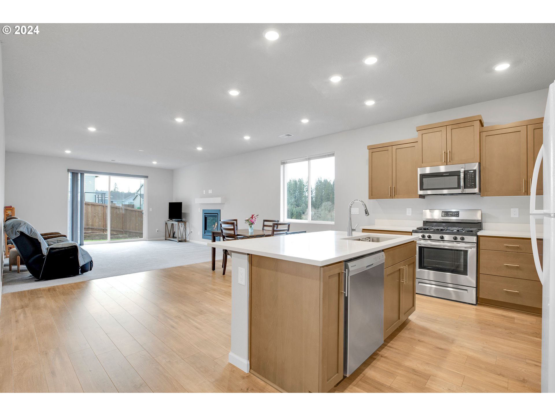 37332 Coho Street Sandy, OR 97055 - Photo 6 of 38 a kitchen with stainless steel appliances granite countertop a stove top oven a sink dishwasher and a refrigerator with wooden floor