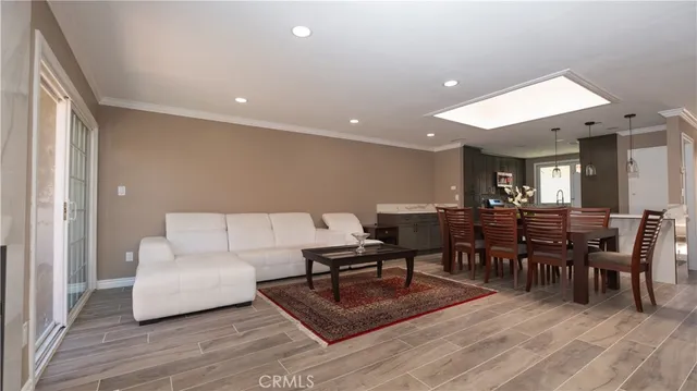 a living room with furniture a dining table and a wooden floor