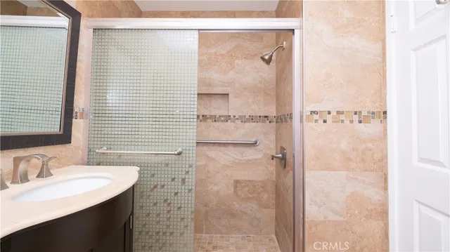 a bathroom with a granite countertop shower sink and mirror