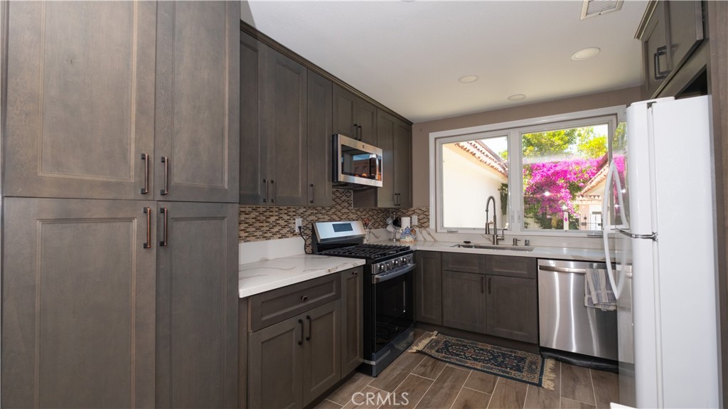 7 Satinwood Way Irvine, CA 92612 - Photo 2 of 15 a kitchen with stainless steel appliances granite countertop a sink and cabinets