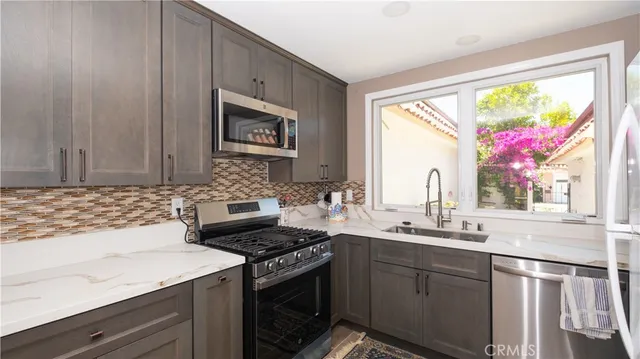 a kitchen with stainless steel appliances a stove sink and cabinets
