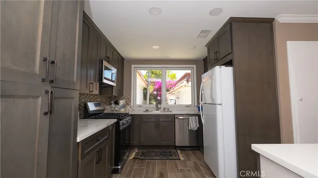 a kitchen with stainless steel appliances a sink stove and refrigerator