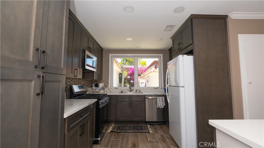 7 Satinwood Way Irvine, CA 92612 - Photo 10 of 15 a kitchen with stainless steel appliances a sink stove and refrigerator
