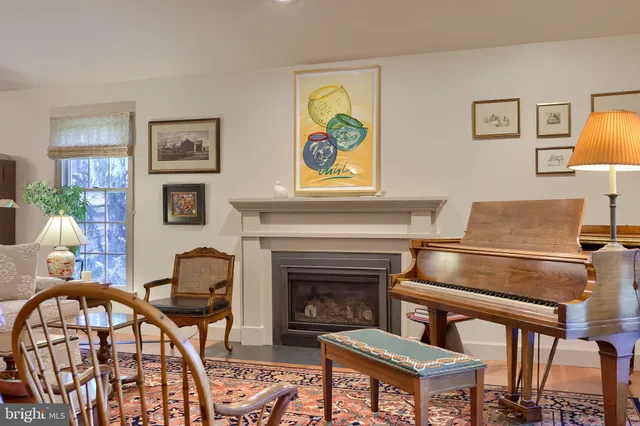 a living room with furniture a piano and a fireplace