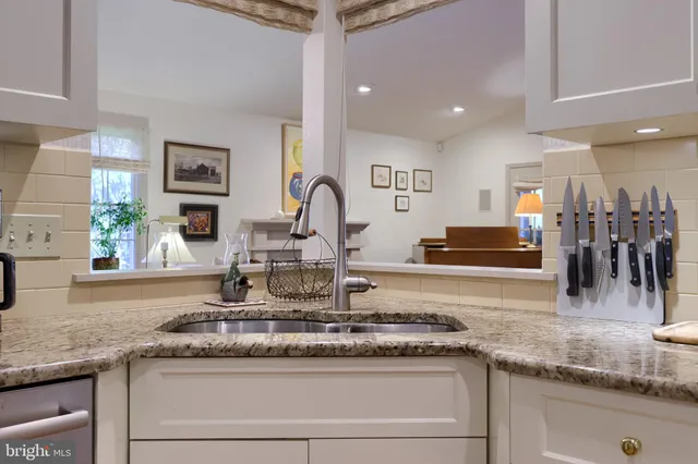 a kitchen with granite countertop a sink and cabinets