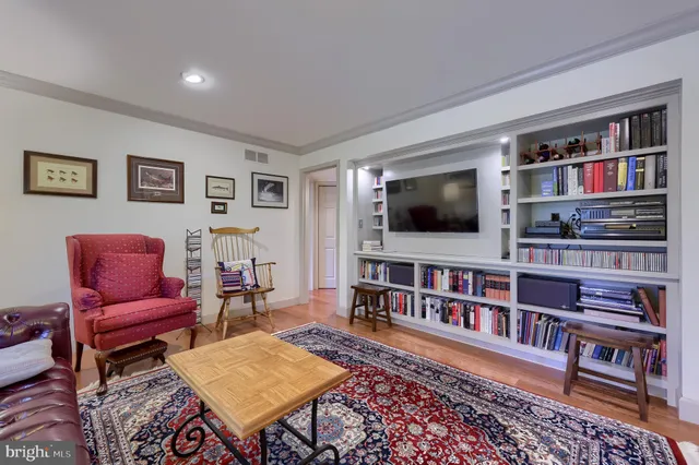 a living room with furniture and a book shelf