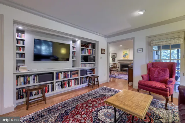 a living room with a bookshelf and a flat screen tv