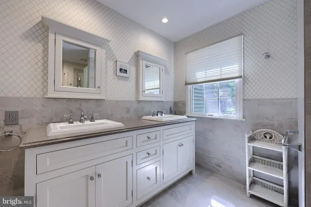 a bathroom with double sink and a mirror