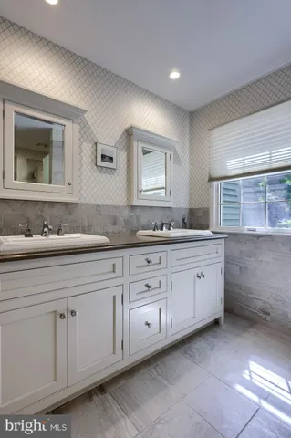 a spacious bathroom with a granite countertop sink and a mirror