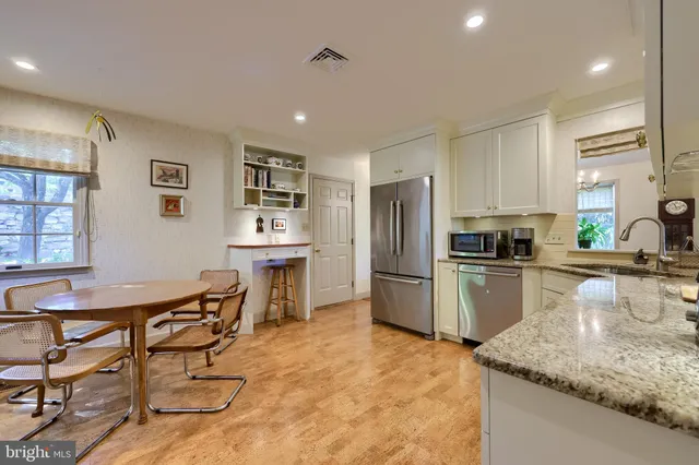 a kitchen with refrigerator and chairs