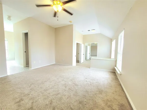an empty room with closet and a chandelier fan