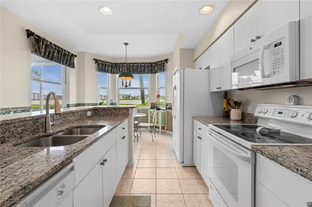 a kitchen with stainless steel appliances granite countertop a sink stove and cabinets