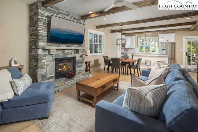 a living room with furniture a flat screen tv and a fireplace