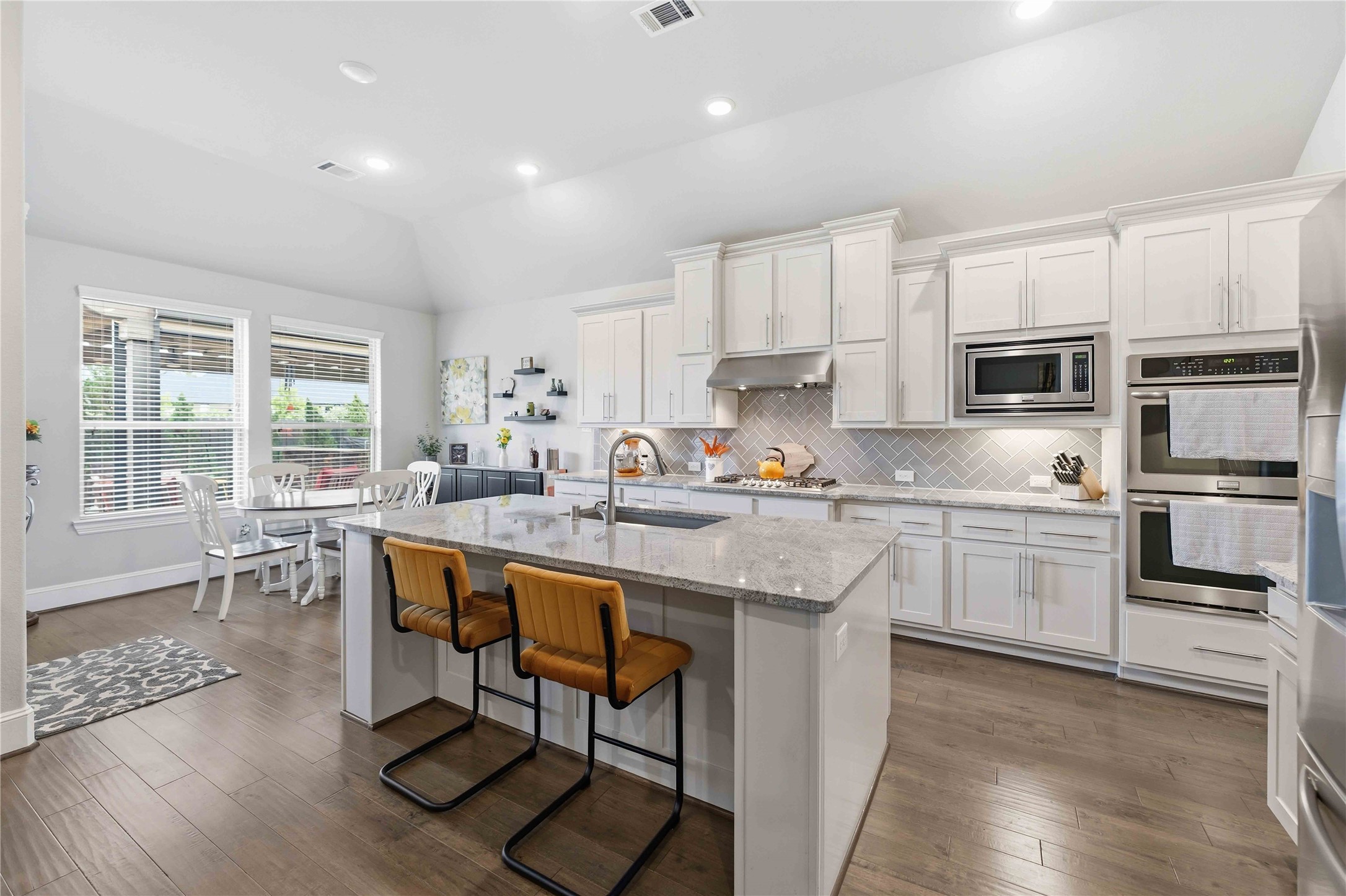 10127 Cooper's Hawk Way Conroe, TX 77385 - Photo 9 of 35 A bright chef's kitchen featuring sleek stainless steel appliances, double ovens, and plenty of cabinet and counter space, as well as a walk in pantry.