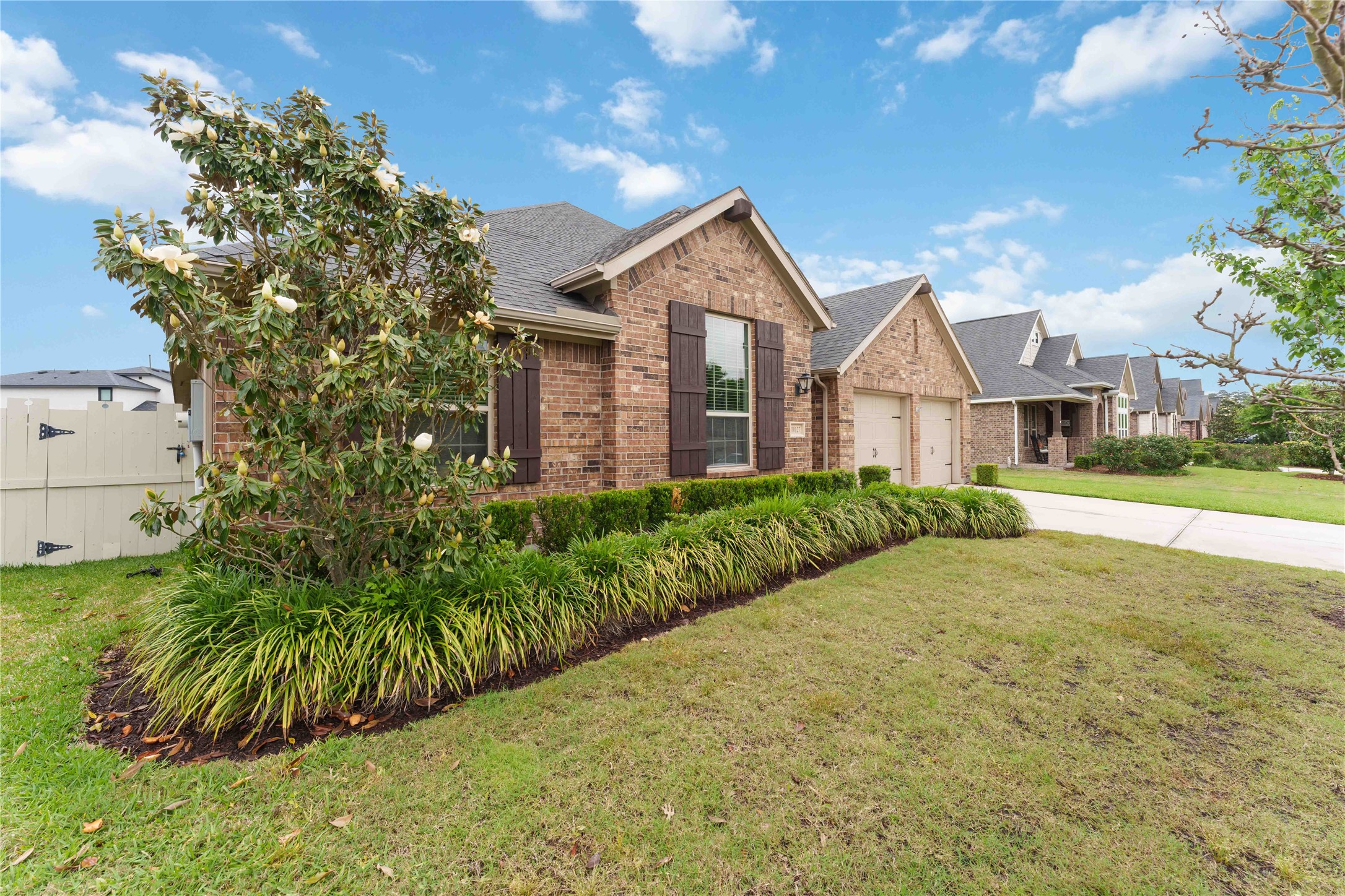 10127 Cooper's Hawk Way Conroe, TX 77385 - Photo 4 of 35 Lush landscaping and a well manicured lawn with mature trees add to this gorgeous home's curb appeal